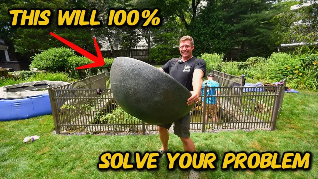 Man lifting large stone in garden